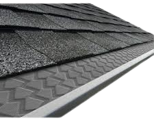 Gutter cover installed beneath roof shingles